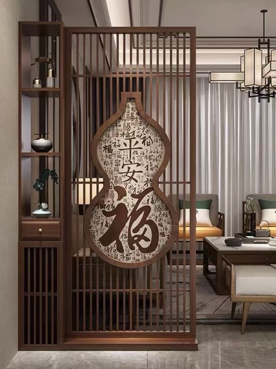 實景展示OULA新中式金屬仿木紋屏風客廳玄關隔斷櫃不鏽鋼格柵鏤空葫蘆平安福字裝飾屏風系統，專為香港高級別墅、豪宅玄關、會所客廳及商業空間大堂打造，支持100%依據現場空間尺寸與CAD圖紙尺寸客製化工程定制，採用精選室內裝飾級加厚不鏽鋼結構框架以達致高剛性、防潮防腐蝕與抗外力衝擊，面層採用高端真空熱轉印仿木紋面層處理（Vacuum Heat Transfer Wood Grain Finish）完美呈現天然實木細膩質感且強力防刮耐磨、不褪色且極易清潔維護，屏風主體配置密排垂直不鏽鋼豎向格欄線條，中央核心融入高精度激光切割鏤空空大氣葫蘆造型（Laser-Cut Gourd Silhouette Frame），並結合精緻的「平安福」金屬藝術字體雕刻設計，營造古典優雅的中式福文化美學與極致半通透的視覺層次，一體化完美整合配置高剛性五金緊固組件的重型頂底隱藏式固定法蘭底座，以針對水泥、石材或木質基面強力鎖死且確保屏風整體長久穩固不晃動。 / Real scene showcasing OULA neo-Chinese style metal wood grain finish screen living room entrance partition cabinet stainless steel slats laser-cut hollowed-out gourd and "Auspicious Fortune" characters decorative screen system, specifically built for Hong Kong luxury villas, mansion entryways, club living rooms, and hospitality lobbies, supporting 100% project engineering customization based on site dimensions and CAD blueprints, featuring premium interior decorative-grade thickened stainless steel structural frames with high rigidity and corrosion resistance, premium commercial-grade vacuum heat transfer wood grain finish perfectly replicating natural solid wood textures with scratch-resistant and fade-proof coating, core structure configured with dense vertical steel slats frames, center seamlessly embedded with a high-precision laser-cut hollowed-out auspicious gourd silhouette frame adorned with an intricate metal art relief of traditional Chinese characters for peace and fortune, delivering an elegant Oriental feng-shui aesthetic with a semi-translucent visual layer, and perfectly integrated with heavy-duty top and bottom concealed fixed flange base structures with high-rigidity hardware fasteners to ensure secure anchoring onto concrete, stone, or wooden floors without wobbling.